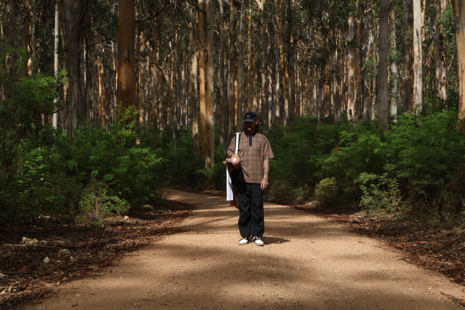 Golfer carrying a sunday bag in forest.
