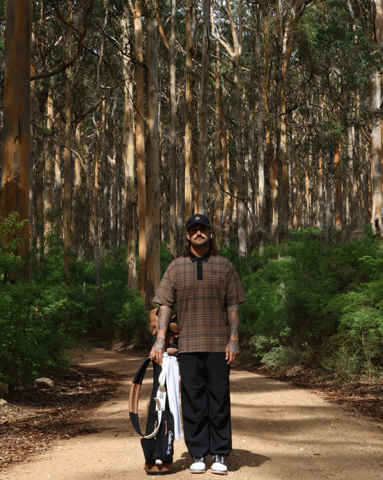 Solace Golf, Golfer in forest resting sunday bag on the ground.