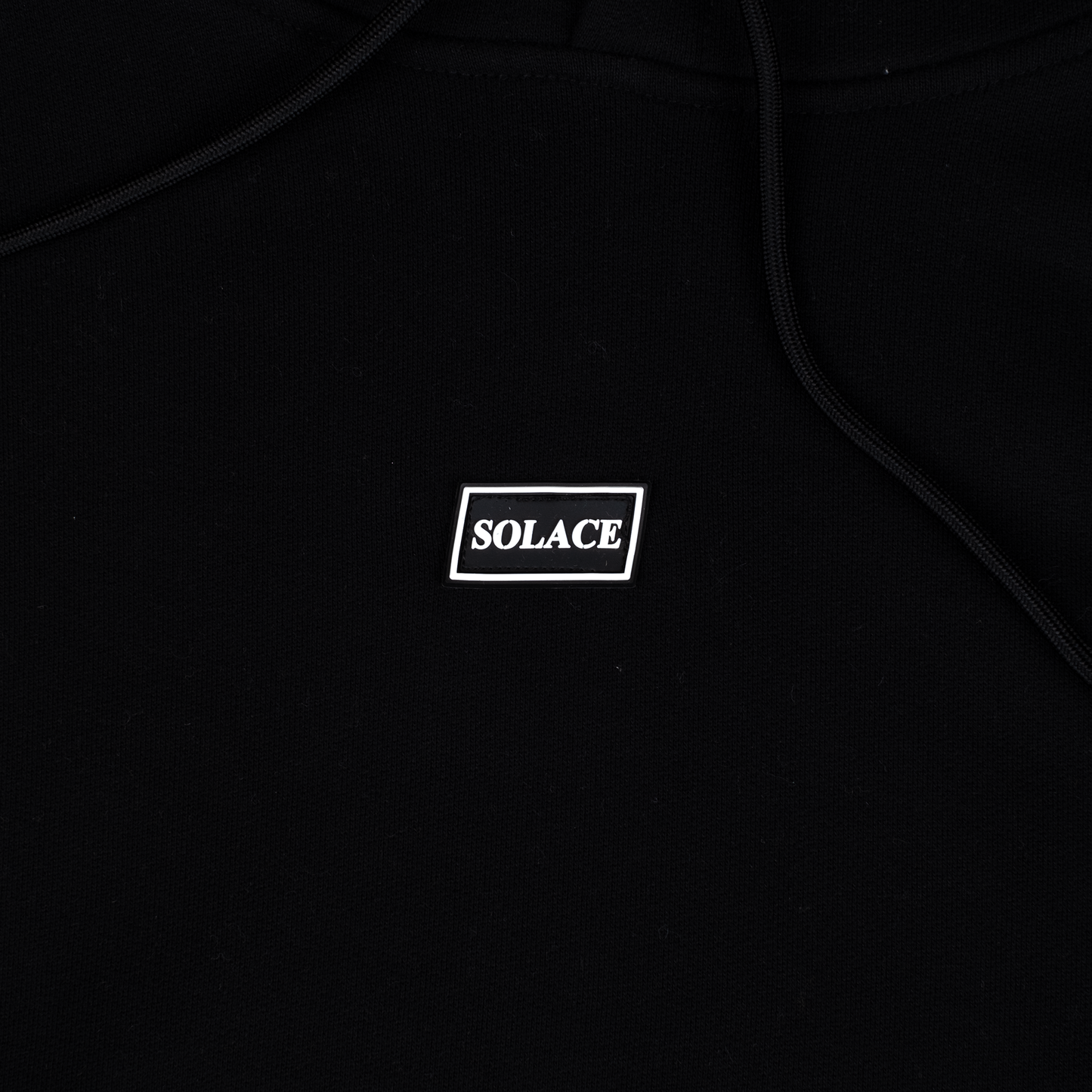 Solace Golf black hoody rubber box logo detail